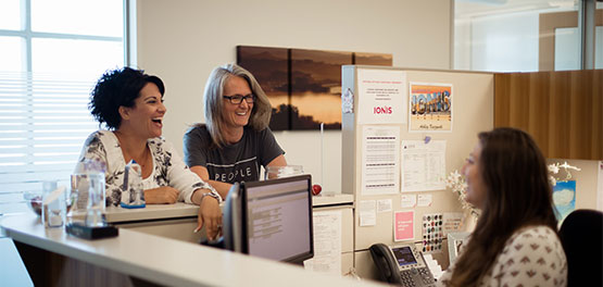 two patients smiling to a receptionist